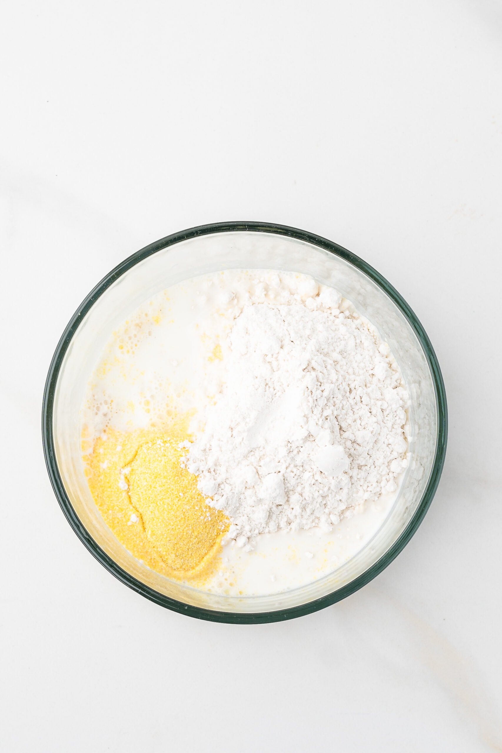Bisquick, cornmeal and milk in a mixing bowl