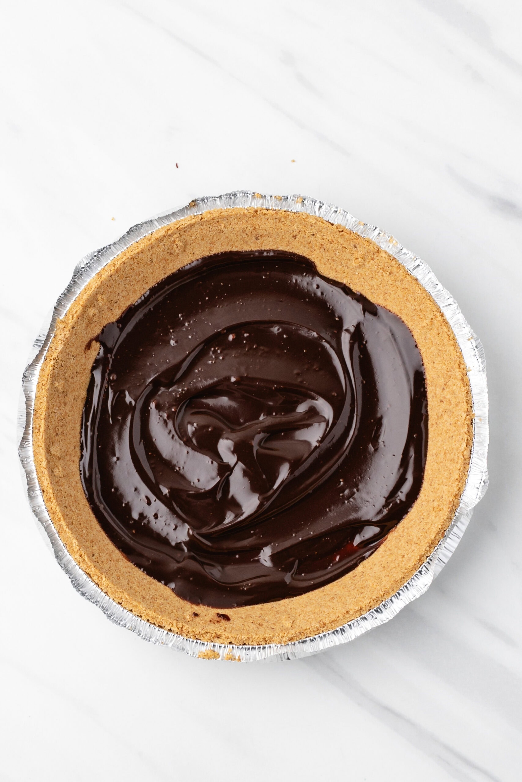 Hot fudge swirled on top of graham cracker crust