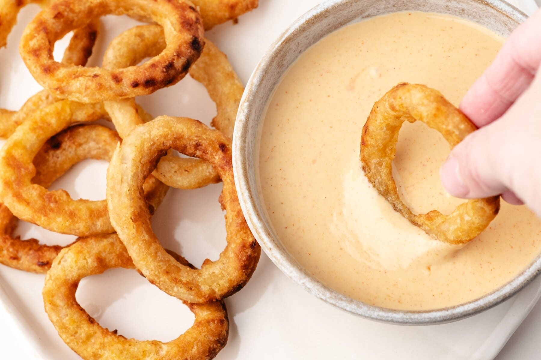 a close up of an onion ring with onion ring dipping sauce