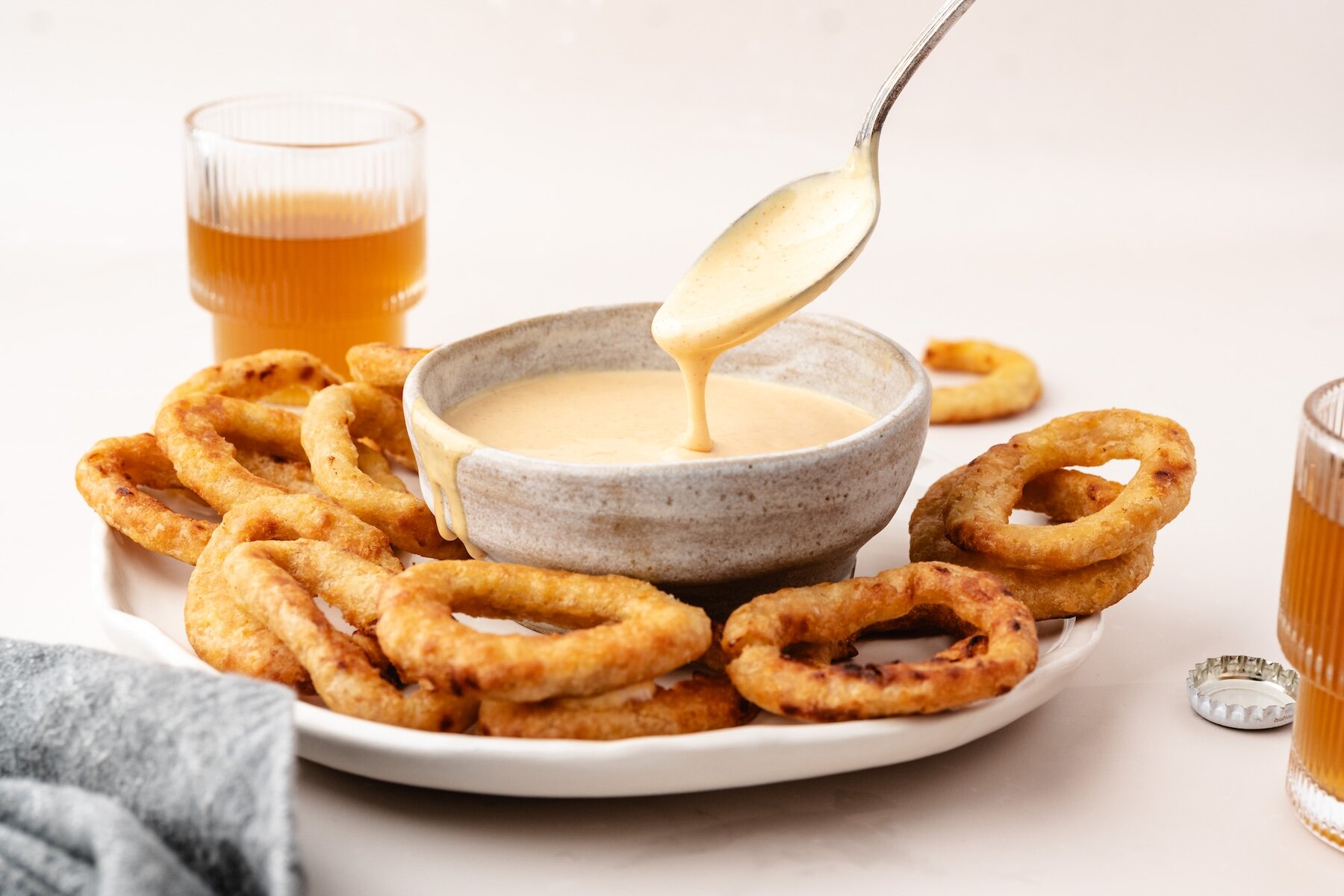 a spoon in zesty onion ring dipping sauce