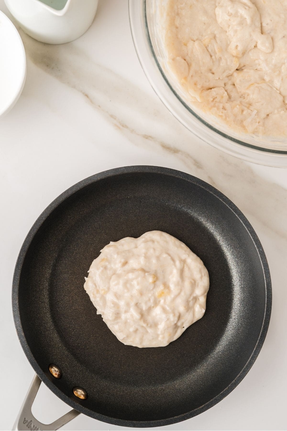 Coconut pancake batter poured onto hot griddle