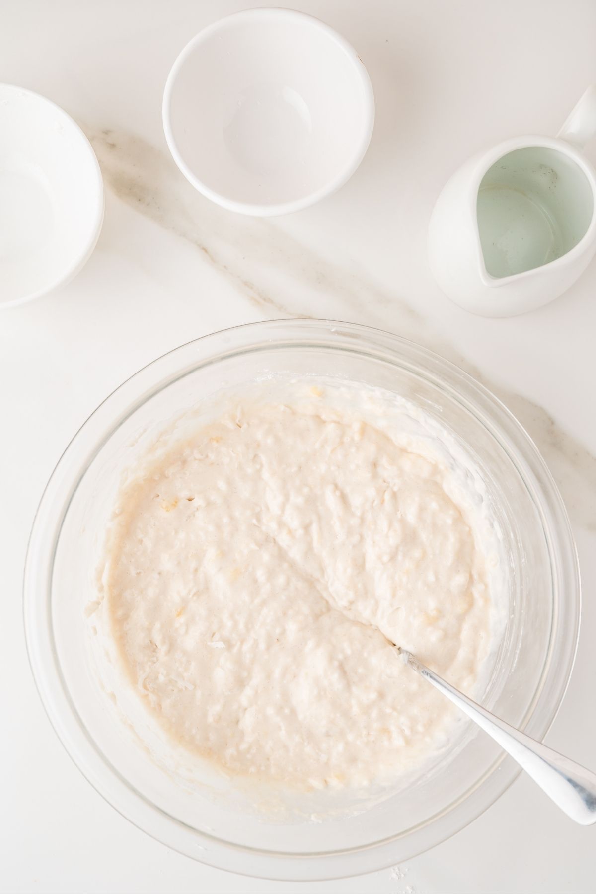 Coconut pancake batter being poured on hot griddle