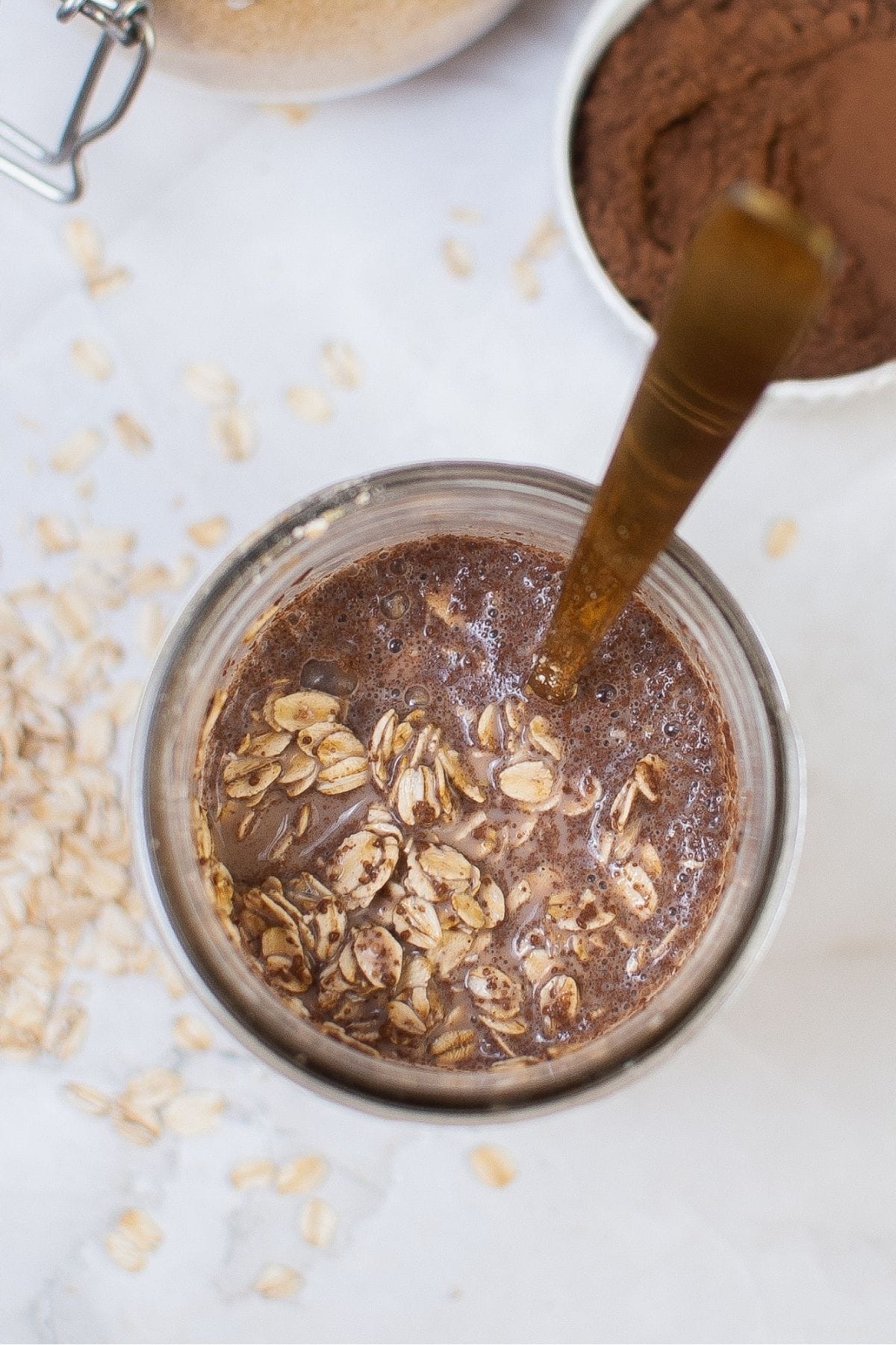 Oats, cocoa powder, and milk mixed in a jar for double chocolate overnight oats