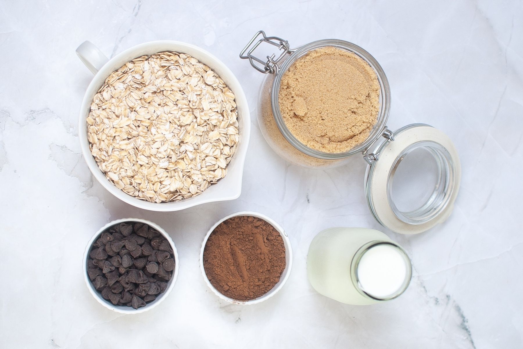 Double chocolate overnight oats ingredients with oats, cocoa, chocolate chips, brown sugar, and milk