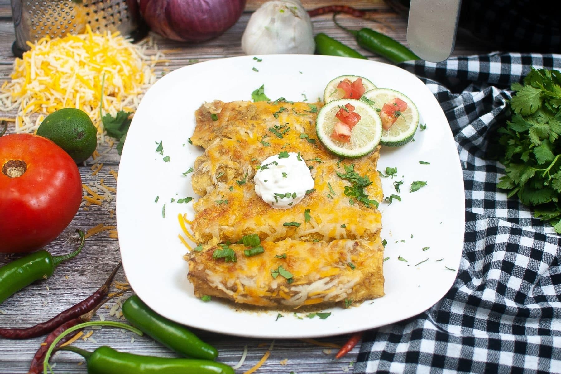 Baked green chili chicken enchiladas served on a plate