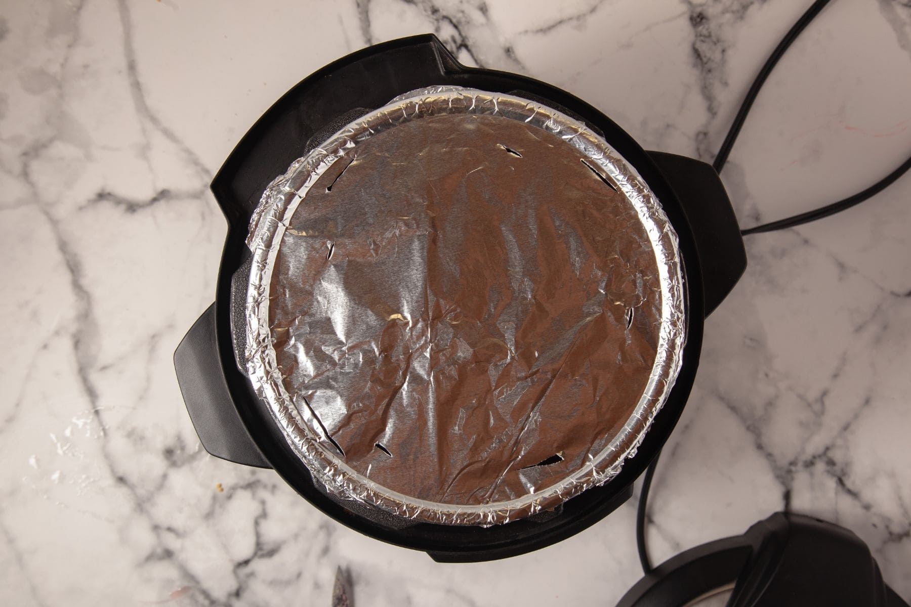 Foil-covered cheesecake pan placed inside Instant Pot