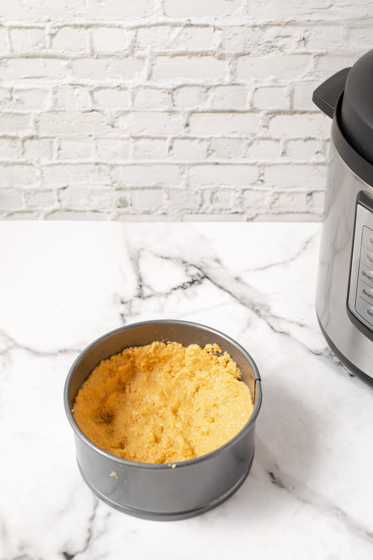 press the Lemon Oreo crumbs into the springform pan