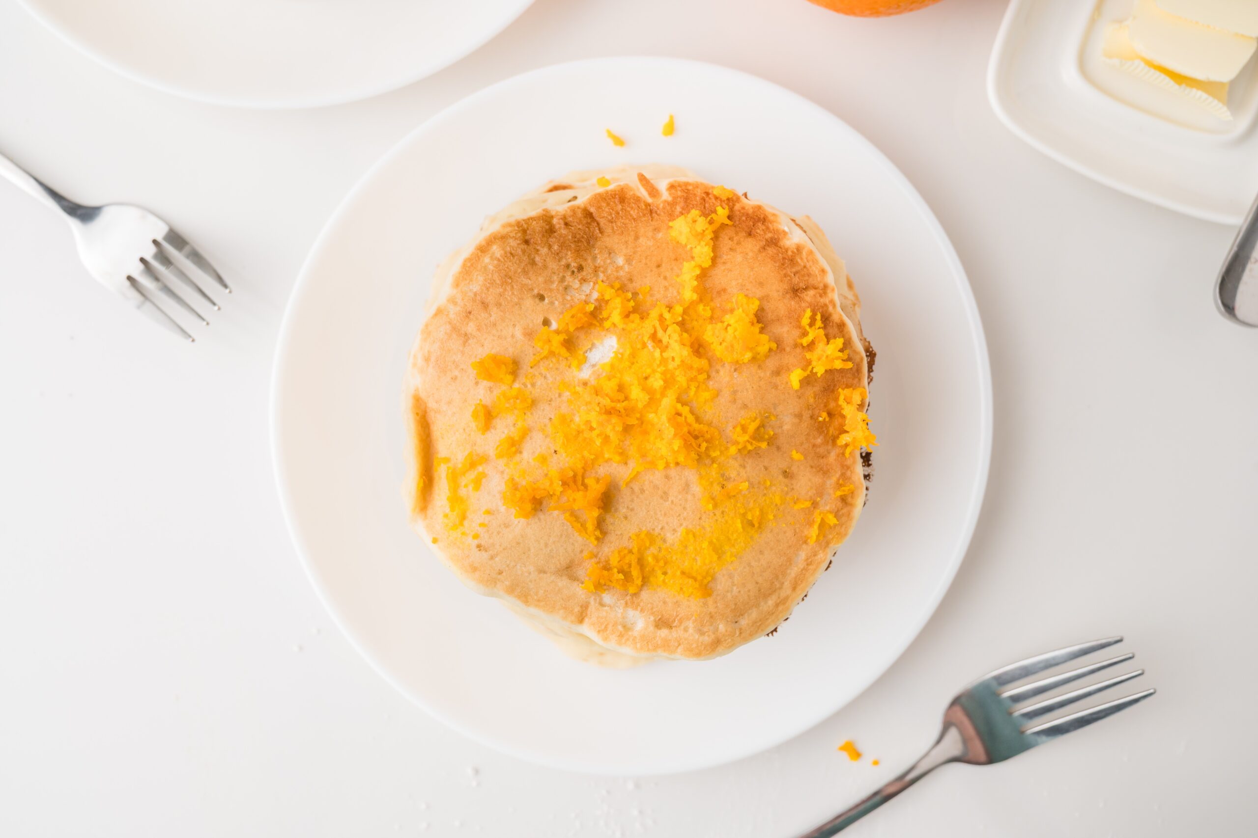 Orange pancakes on white plate