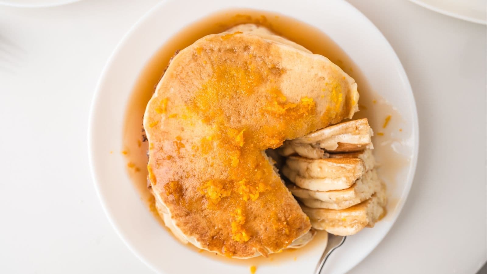 Orange pancakes stacked on plate