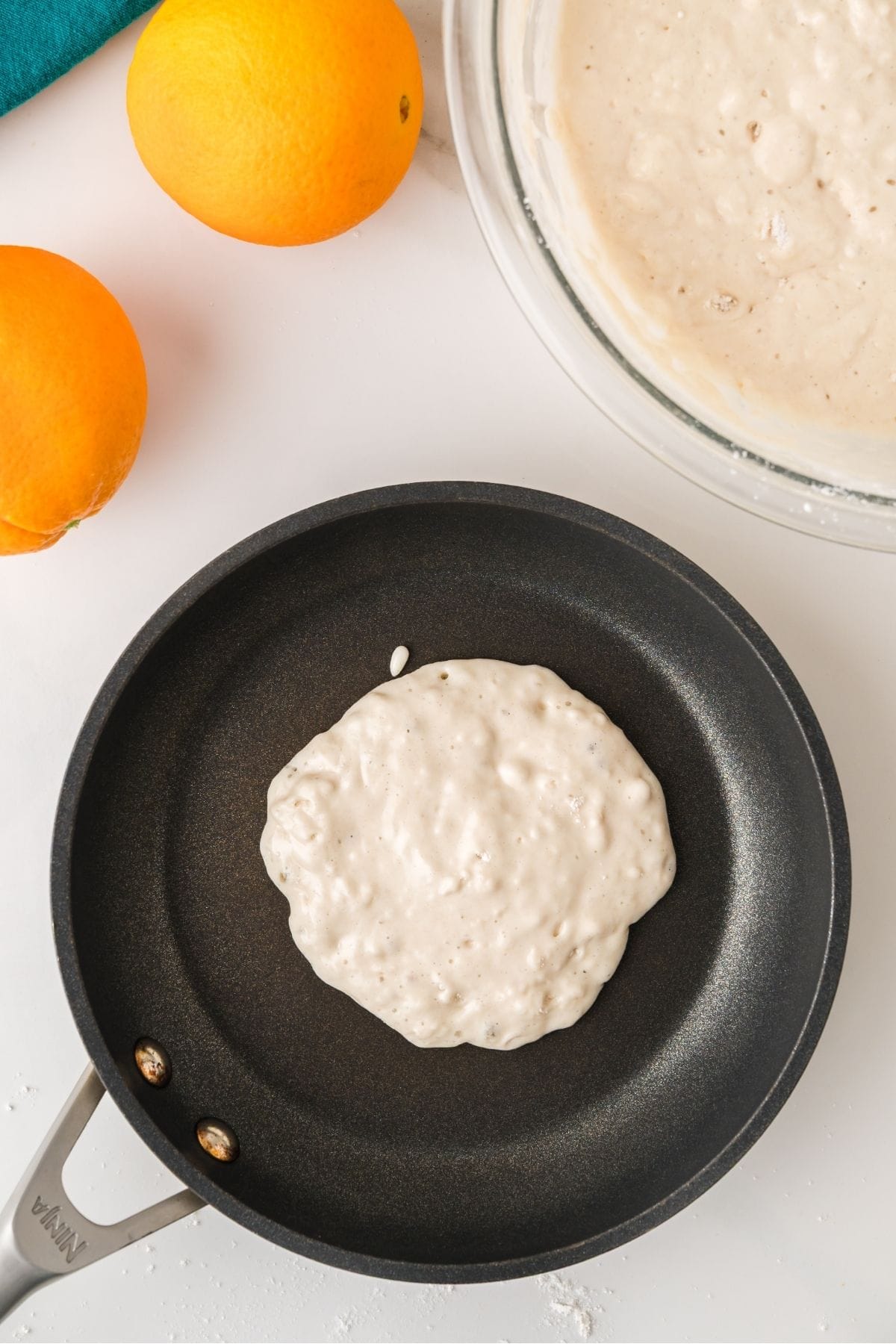 Orange pancake batter poured on hot griddle