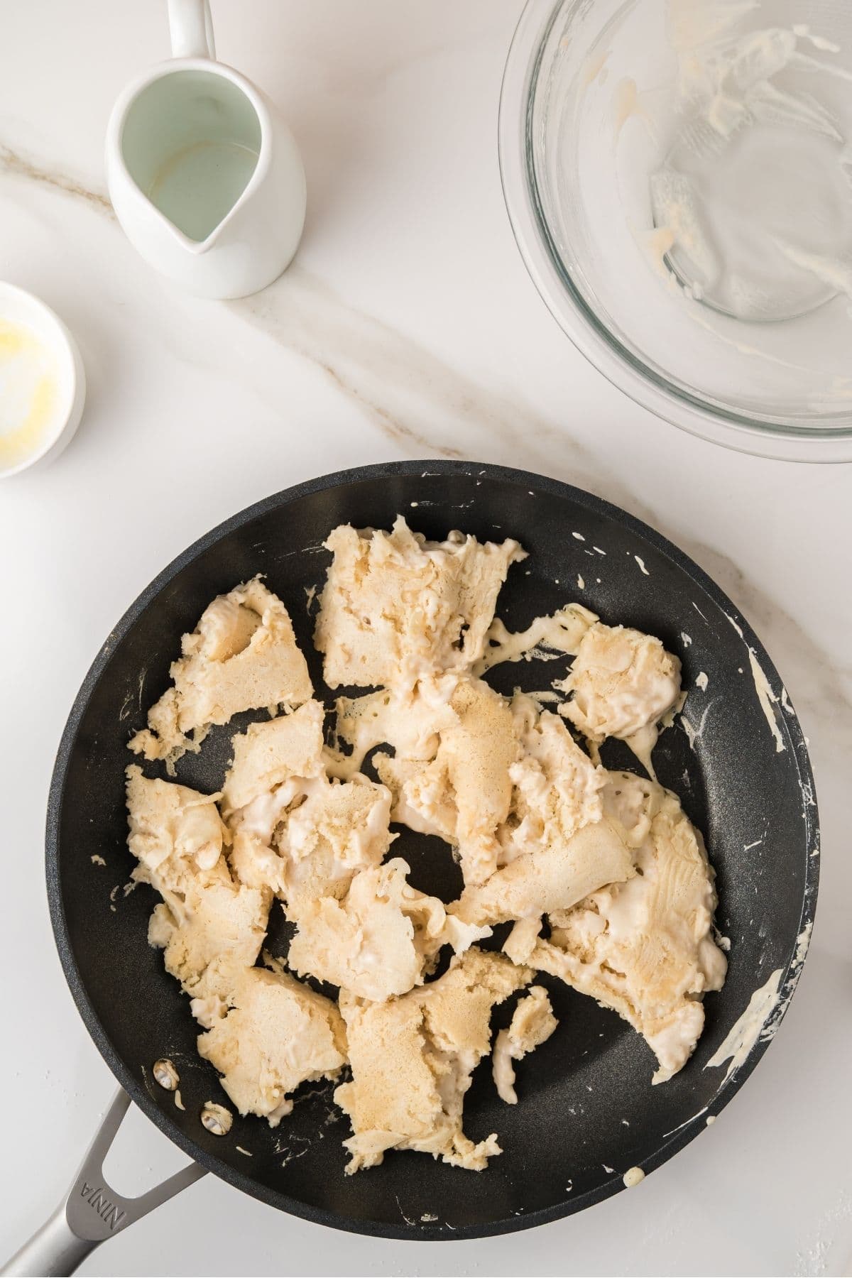 Scrambled pancakes being stirred into pieces on pan