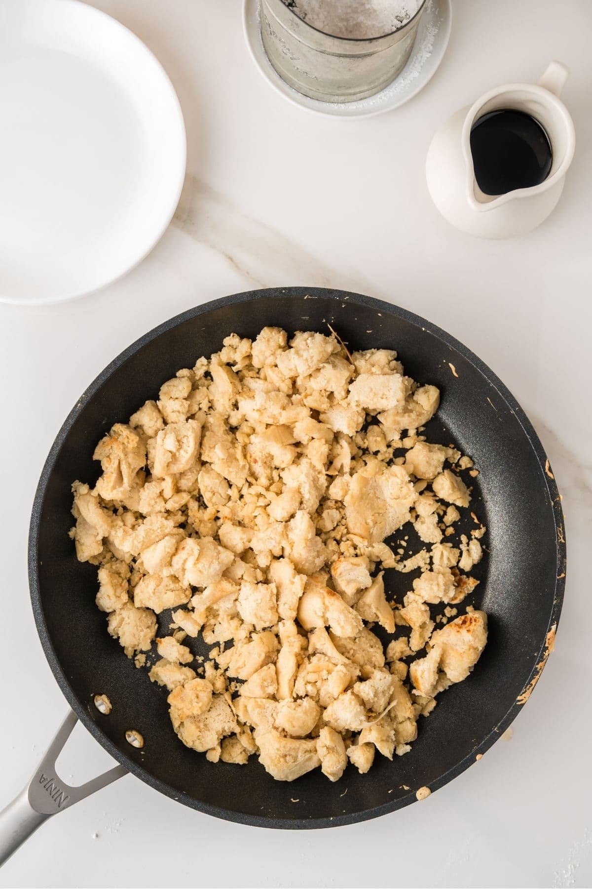 Scrambled pancake batter cooking on a hot skillet.