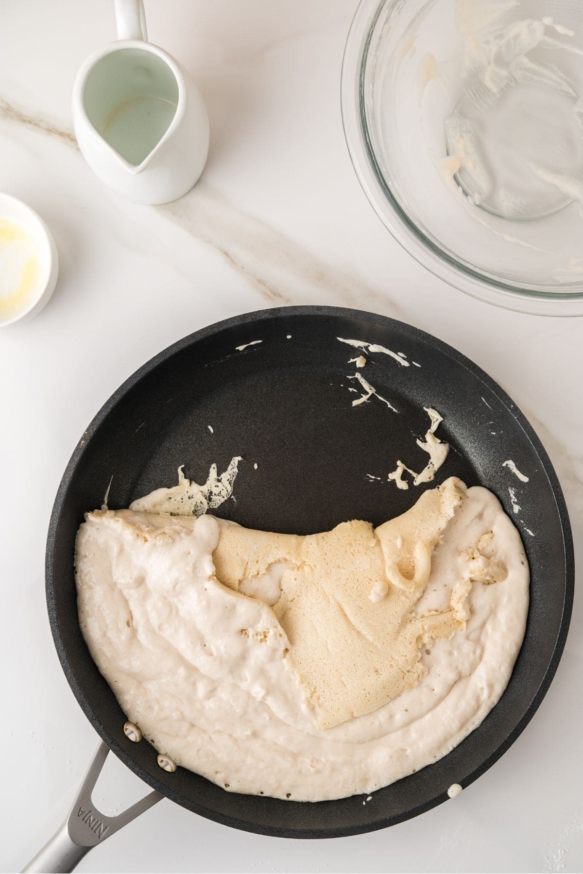 Pancake batter cooking in pieces on skillet