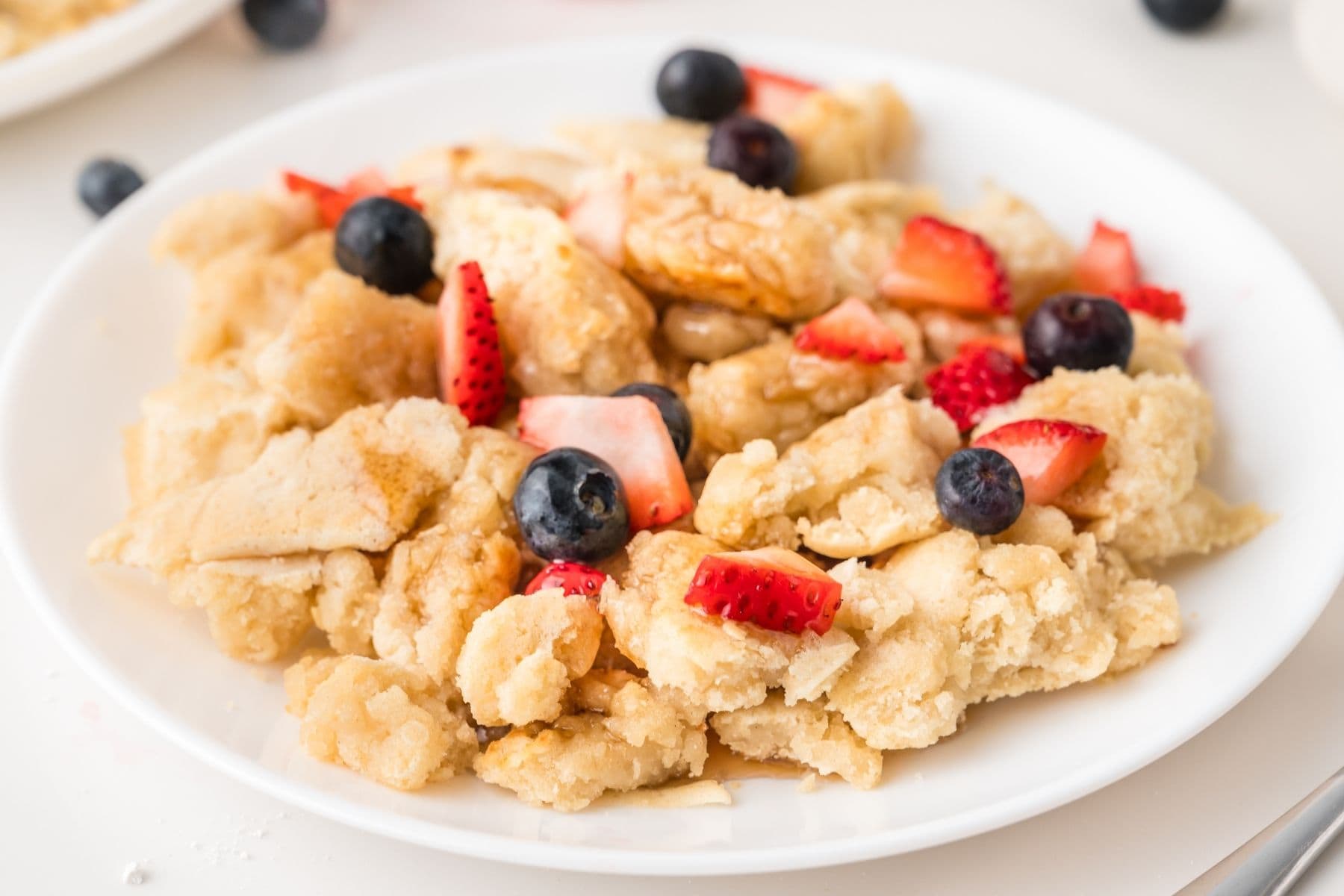 Golden scrambled pancakes piled on a plate
