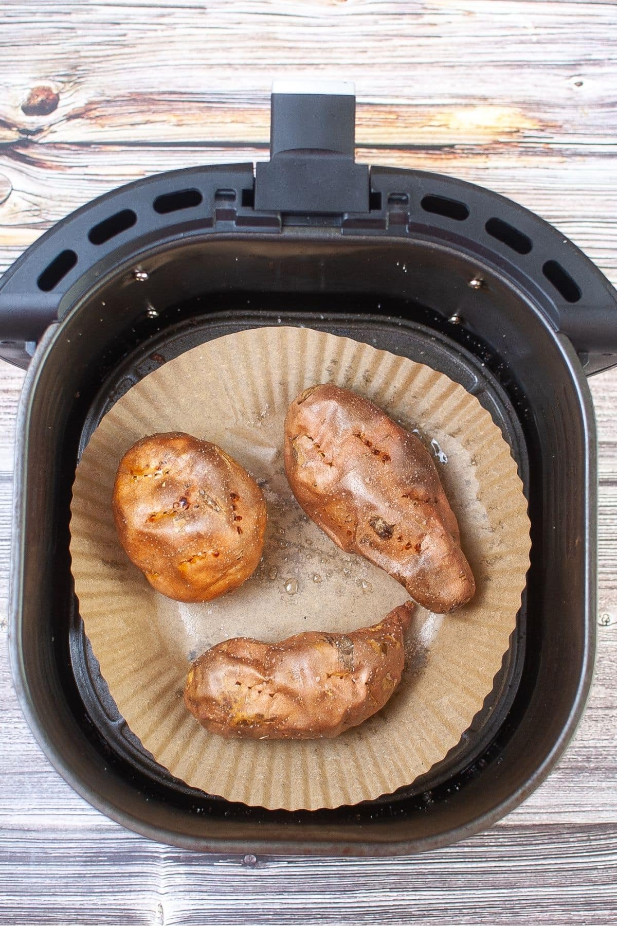 Sweet potatoes cooking in air fryer basket