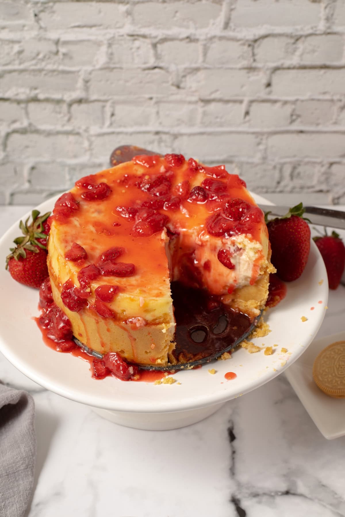 homemade strawberry sauce poured over a fresh cheesecake