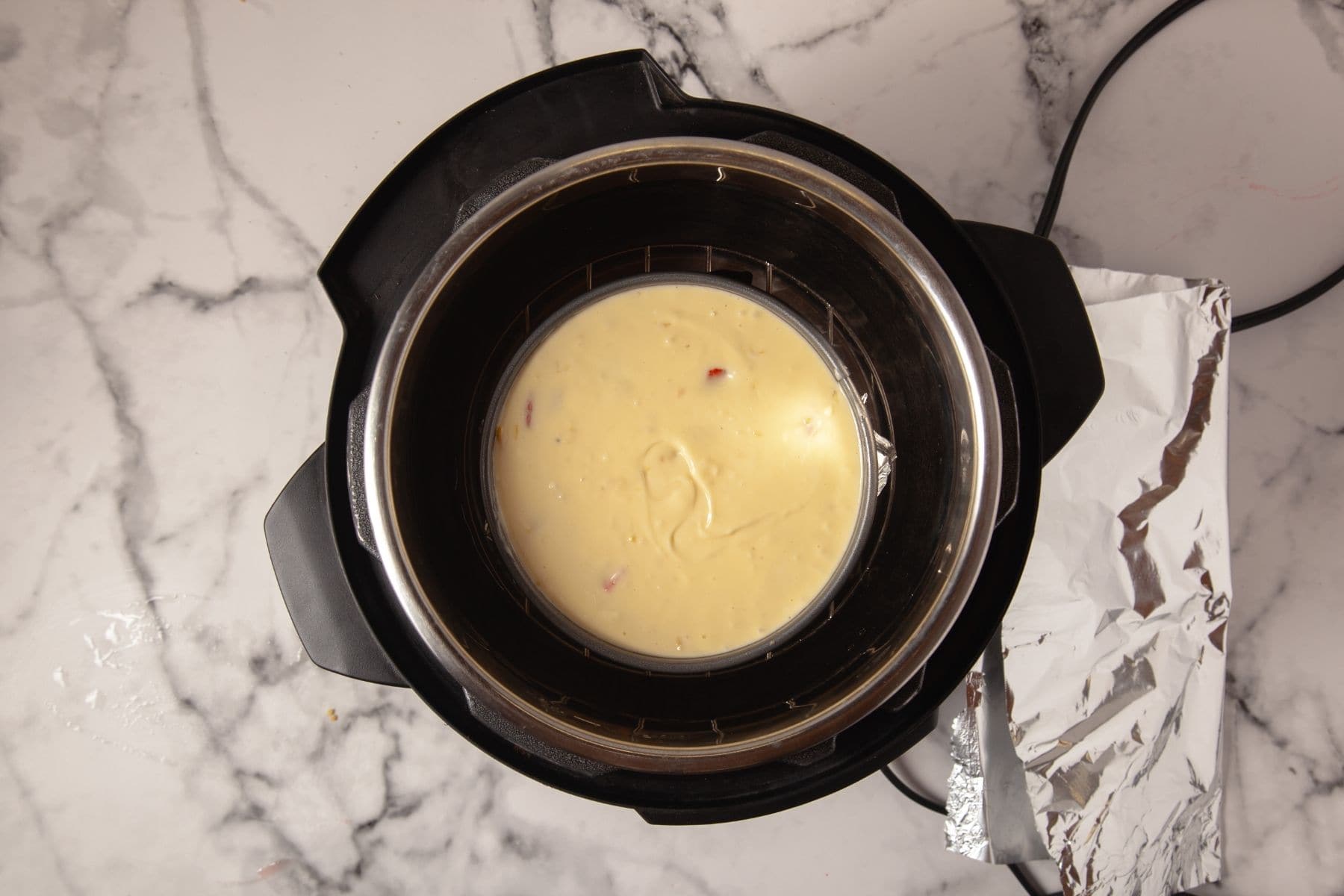 Strawberry cheesecake batter in pan inside Instant Pot