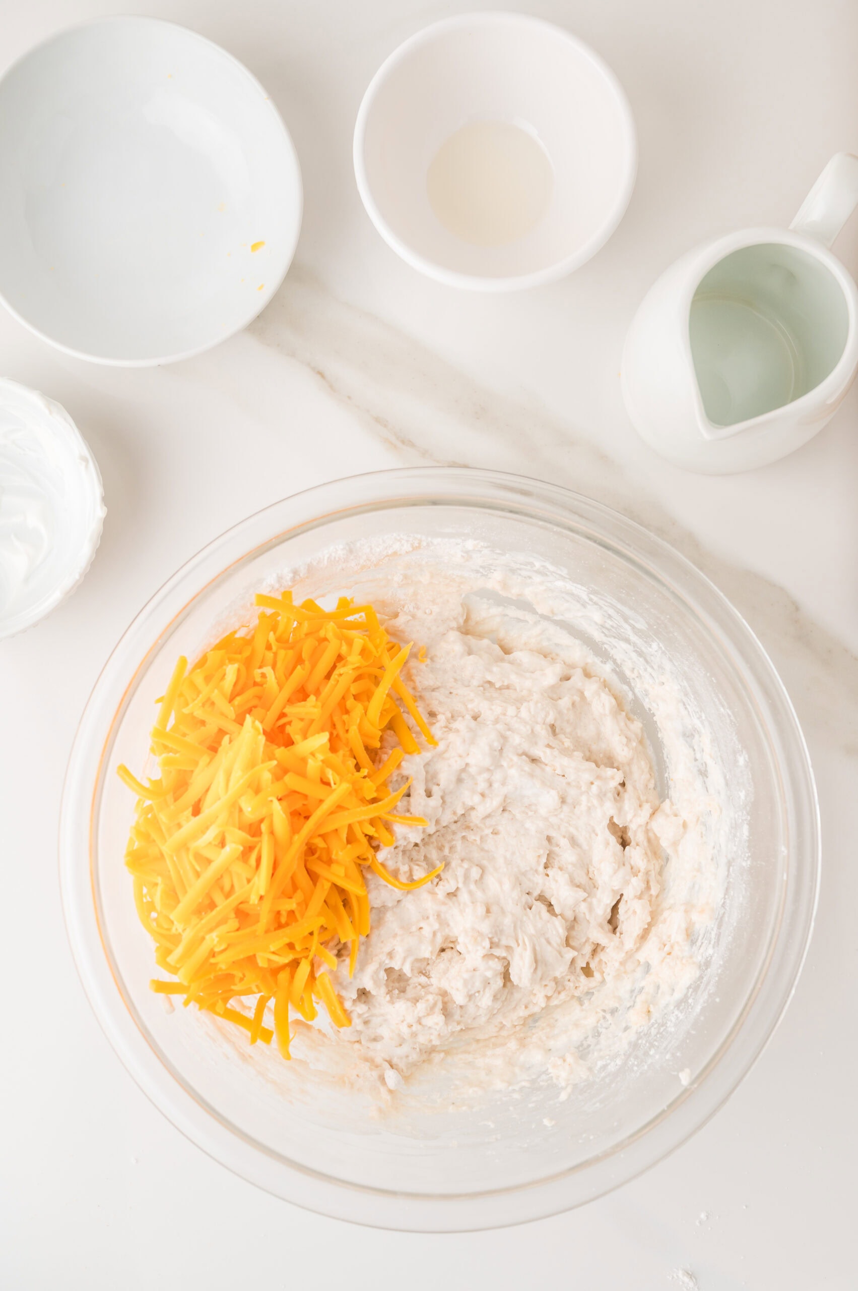 Adding shredded cheddar cheese to savory muffin batter