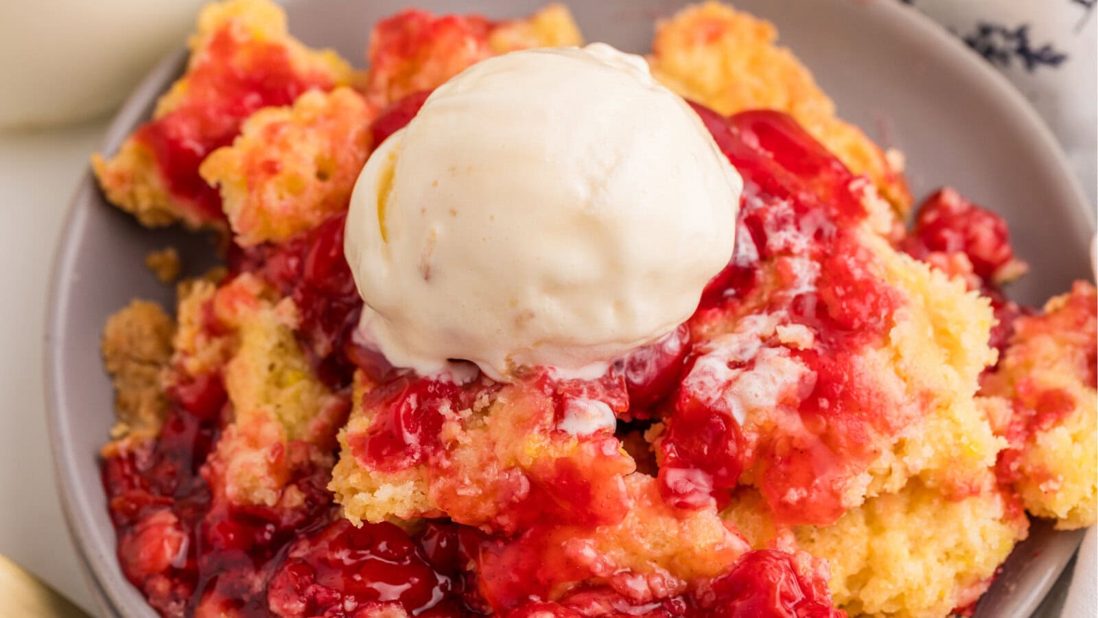 Cherry dump cake with melted vanilla ice cream