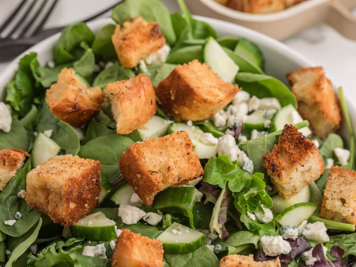 Golden homemade croutons topping spinach salad