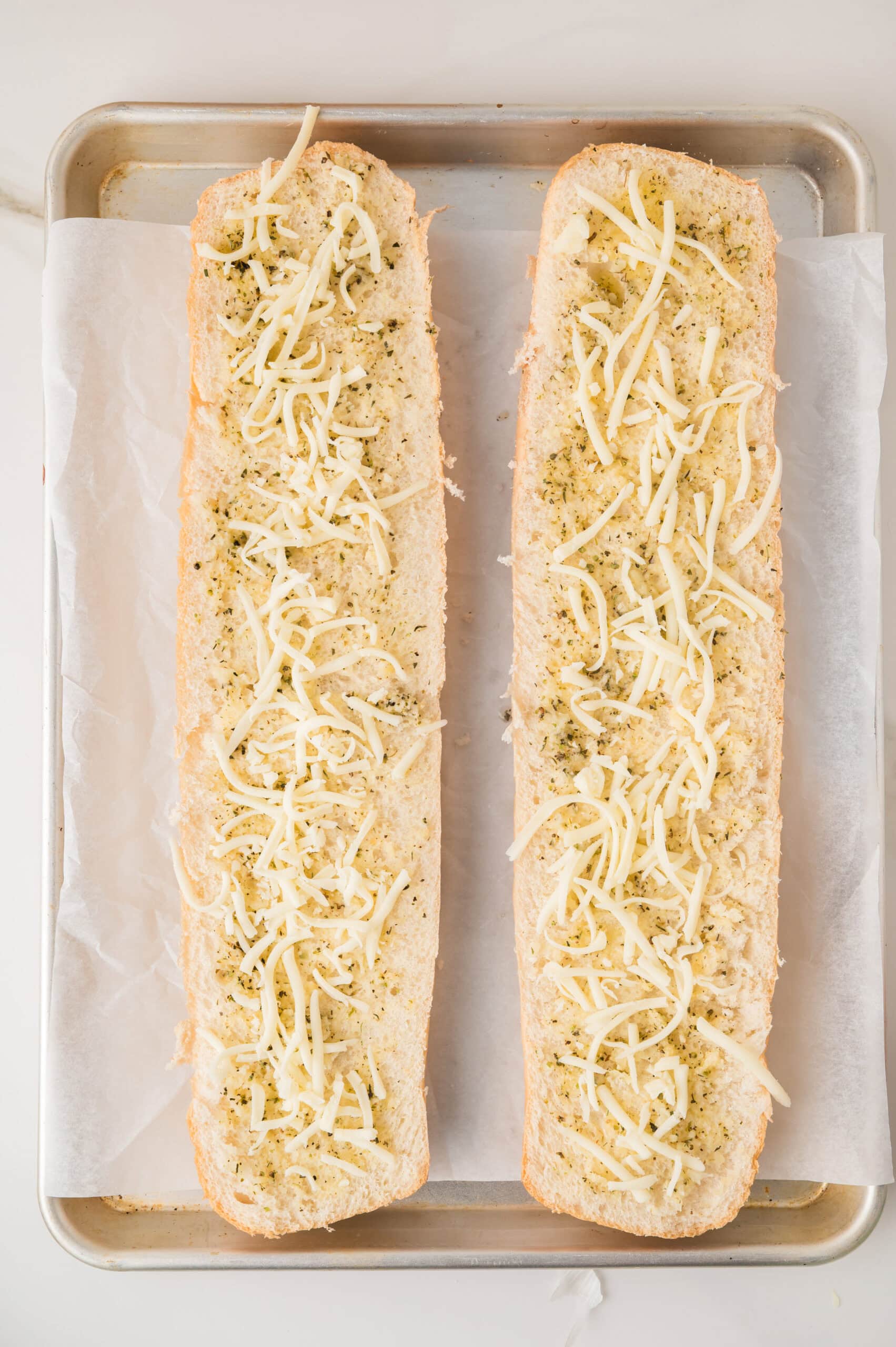 Garlic bread pizza preparation with shredded mozzarella